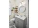 Bright bathroom featuring a vanity, round mirror, and decorative floating shelves enhancing the overall aesthetic appeal at 213 Cannon St, Lakeland, FL 33803