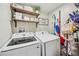 Laundry room featuring a front loading washer, side-by-side dryer, and rustic shelving at 213 Cannon St, Lakeland, FL 33803