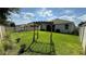 Spacious backyard with lush green grass, mature trees, and shaded dining area with a white fence at 2169 Rush Bay Way, Orlando, FL 32824