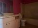Outdated bathroom with a pink wall, a basic vanity, toilet, and bathtub that needs renovation at 2250 Maple Hill Dr, Lakeland, FL 33811