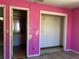 Bedroom with pink walls, an open closet, and a view of a bathroom, shows repairs needed at 2250 Maple Hill Dr, Lakeland, FL 33811