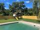 Backyard showcasing a refreshing pool and a charming elevated playhouse for outdoor enjoyment at 2250 Maple Hill Dr, Lakeland, FL 33811
