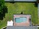 Aerial view of backyard featuring a pool with screen enclosure and a large green lawn at 2264 Palmview E Cir, Auburndale, FL 33823