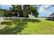 Large, green backyard with a tall privacy fence and mature tree at 2264 Palmview E Cir, Auburndale, FL 33823
