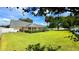 Expansive backyard showcasing a screened-in lanai, verdant lawn, and manicured hedges at 2264 Palmview E Cir, Auburndale, FL 33823