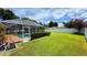 Expansive backyard with a sparkling screened-in pool and lush green lawn at 2264 Palmview E Cir, Auburndale, FL 33823