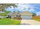 Charming single-story home with dormer windows, landscaped yard, and a two car garage on a sunny day at 2264 Palmview E Cir, Auburndale, FL 33823
