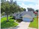 Charming single-story home with a well-manicured lawn, lush landscaping, and an attached two car garage at 2264 Palmview E Cir, Auburndale, FL 33823