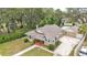 Overhead shot of a well-kept house, featuring a large yard, driveway, and leafy surrounding trees at 236 E Seminole Ave, Lake Wales, FL 33853