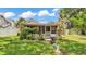 Backyard view of the house with a screened-in porch, complemented by potted plants and green grass at 236 E Seminole Ave, Lake Wales, FL 33853