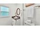 Clean white bathroom with single sink, dark granite countertop and traditional mirror at 236 E Seminole Ave, Lake Wales, FL 33853