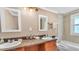 Bright bathroom featuring double sinks, granite countertops, and traditional cabinets at 236 E Seminole Ave, Lake Wales, FL 33853