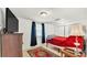 Simple bedroom with a red blanket, white walls, tile floors, and a window with dark curtains at 236 E Seminole Ave, Lake Wales, FL 33853