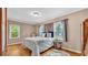 Light filled bedroom featuring wood floors, cream-colored walls, and two windows at 236 E Seminole Ave, Lake Wales, FL 33853