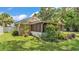 Enclosed back porch surrounded by lush plants and trees at 236 E Seminole Ave, Lake Wales, FL 33853