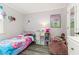 Charming bedroom featuring gray plank flooring, a cozy bed, fun storage, and a relaxing beanbag chair at 2443 Delrose E Dr, Lakeland, FL 33805