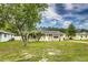 Charming single-story home with well-manicured lawn, small palm trees, and inviting front entrance at 2443 Delrose E Dr, Lakeland, FL 33805