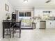 Modern kitchen with white cabinets, stainless steel appliances, and a dining area at 2443 Delrose E Dr, Lakeland, FL 33805