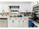 Bright kitchen featuring white cabinets, stainless steel appliances, a double sink and a window with a garden view at 2443 Delrose E Dr, Lakeland, FL 33805