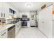 Efficient kitchen features stainless steel appliances, white cabinets, and nearby laundry area at 2443 Delrose E Dr, Lakeland, FL 33805