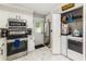 Kitchen featuring stainless steel appliances, white cabinets, and a convenient laundry setup at 2443 Delrose E Dr, Lakeland, FL 33805