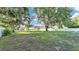 Expansive backyard with mature trees, a white fence, and a view of the home's exterior at 2533 Peterson Rd, Lakeland, FL 33812