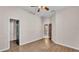 Bedroom with wood floors, ceiling fan, and doors to the bathroom and closet at 2533 Peterson Rd, Lakeland, FL 33812