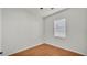 A simple bedroom includes wood floors, neutral paint, and a window that brings in natural light at 2533 Peterson Rd, Lakeland, FL 33812