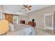 A spacious bedroom with a barn door leading to the ensuite bathroom, tray ceiling, and neutral walls and flooring at 2533 Peterson Rd, Lakeland, FL 33812