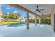 Covered patio with ceiling fans overlooks the pool and fenced backyard with mature trees at 2533 Peterson Rd, Lakeland, FL 33812