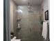 Modern bathroom showcases a glass-enclosed shower with sleek fixtures, shelving, and neutral tile at 301 Orange Blossom Dr, Winter Haven, FL 33880
