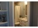 Well-lit bathroom features a shower/tub combination, stylish vanity, and decorative shelving for storage at 301 Orange Blossom Dr, Winter Haven, FL 33880