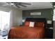 Cozy bedroom with a balcony, ceiling fan, and a modern design with an orange comforter at 301 Orange Blossom Dr, Winter Haven, FL 33880