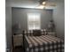 Neutral bedroom featuring a cozy queen bed, shuttered window, and matching nightstands with lamps at 301 Orange Blossom Dr, Winter Haven, FL 33880