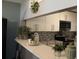 Contemporary kitchen featuring white cabinetry, stainless steel appliances, and decorative accents at 301 Orange Blossom Dr, Winter Haven, FL 33880