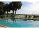 Sparkling community pool area with chairs, palm trees, and lake views at 301 Orange Blossom Dr, Winter Haven, FL 33880