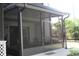 Exterior view of a spacious screened-in porch with ceiling fan offering shade at 301 Orange Blossom Dr, Winter Haven, FL 33880