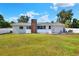 Large backyard with manicured lawn and exterior view of the house with the brick chimney at 3522 Royal S Ct, Lakeland, FL 33812