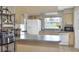 Bright kitchen with an island, white appliances, light wood cabinets and a window to brighten the space at 3522 Royal S Ct, Lakeland, FL 33812