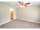 Cozy bedroom with ceiling fan, soft carpet, and a view into the ensuite bathroom at 4042 Old Bartow Eagle Lake Rd, Bartow, FL 33830