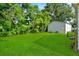 Spacious backyard with lush greenery and a storage shed at 405 S 7Th Ave, Bartow, FL 33830