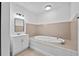 This bathroom features a modern vanity with white cabinet and a large soaking tub at 405 S 7Th Ave, Bartow, FL 33830