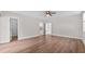 This bedroom has wood-look floors, a ceiling fan, and doors to other rooms and the bathroom at 405 S 7Th Ave, Bartow, FL 33830