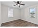 This bedroom offers a ceiling fan, wood-look floors and two bright windows at 405 S 7Th Ave, Bartow, FL 33830