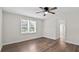 Bedroom featuring hardwood floors, a window, and a ceiling fan at 405 S 7Th Ave, Bartow, FL 33830