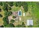 Aerial view of the property showcases a house with a pool, surrounding trees, outbuildings, and a barn at 4510 Cindy Rd, Lakeland, FL 33810