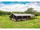 Exterior side view of a horse barn, set on a lush green field at 4510 Cindy Rd, Lakeland, FL 33810