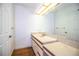 Modest bathroom with marble countertops and wood-look flooring and large mirror at 4510 Cindy Rd, Lakeland, FL 33810