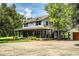 Inviting two-story home featuring a wrap-around porch, beautiful landscaping, and mature trees at 4510 Cindy Rd, Lakeland, FL 33810
