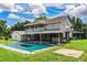 Back exterior view of the home showcasing the expansive backyard, pool, and covered patio at 4510 Cindy Rd, Lakeland, FL 33810